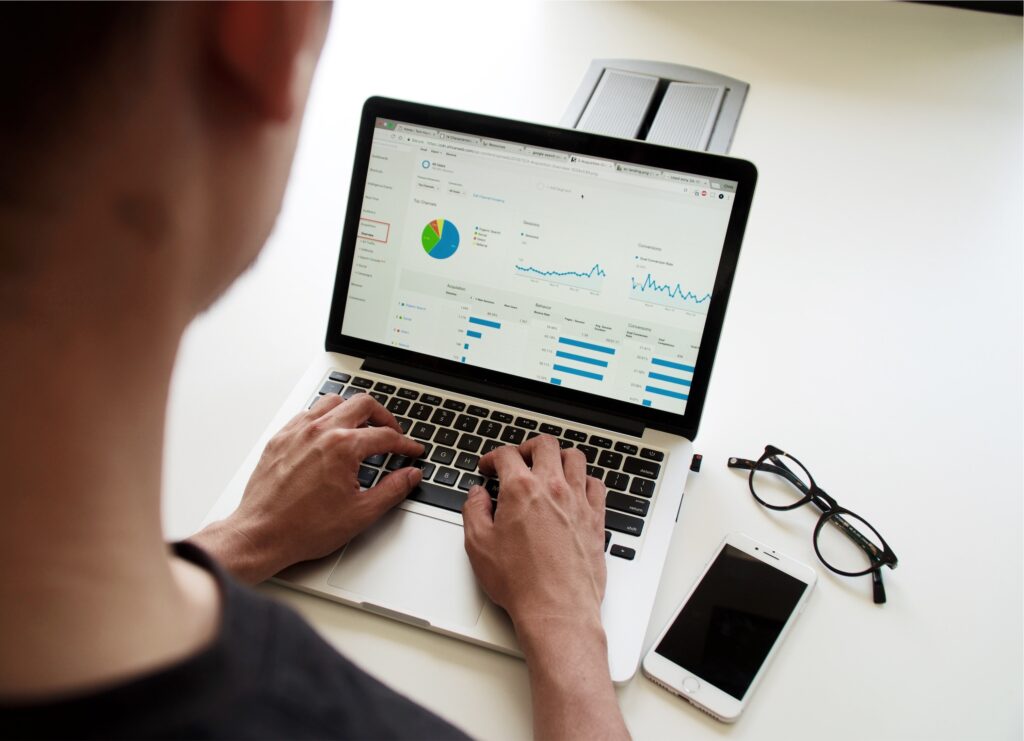 Photo of a person looking at a computer screen that displays charts and graphs, presumably of digital data analytics