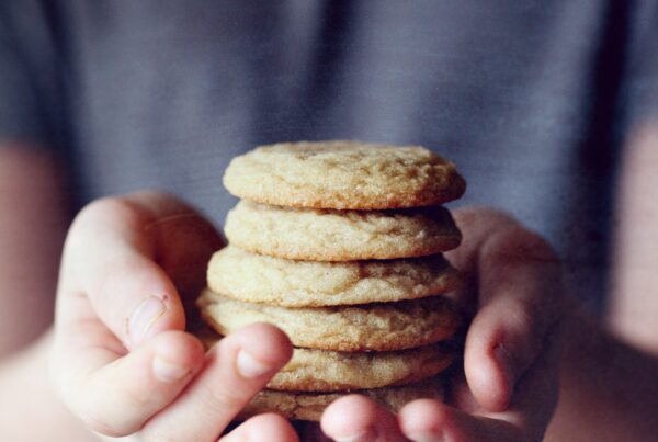 Photo of a person's hands holding a stack of cookies, evoking a fond feeling of browser cookies being collected by a third party